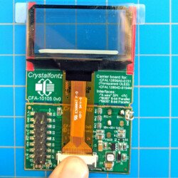 Display inserted into ZIF connector on breakout board with finger to close ZIF connector