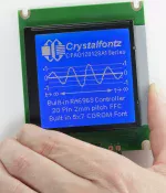 CFAG128128A1-TMI-TZ, white on blue graphic LCD,in hand to show size and perspective.