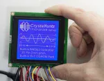 128x128 Blue on White Graphic LCD, in-hand to show size and perspective.