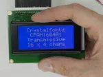 16x4 parallel character LCD with White characters on a blue background. Front view, in hand to show size and perspective.