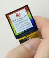 240x240 square color TFT LCD, in hand, powered on to show perspective.