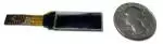 The CFAL12832D-B is a 0.91 inch 128x32 white-on-black graphic OLED - front view, power off. Size compared to an American 25 cent piece. Unfolded FPC ZIF tail is complete.