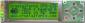 20x4 Serial RS232 LCD Display Module with Back light off. Black letters on yellow-green background. 4 variable colored status LED lights and 6 button illuminated, programmable keypad.