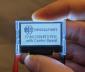 128x64 Backlit Transflective Graphic LCD Display with breakout board, in -hand to show size and perspective.