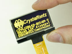 128x64 Yellow Graphic OLED 1.54 inch diagonal. In hand to show size and perspective, powered on.